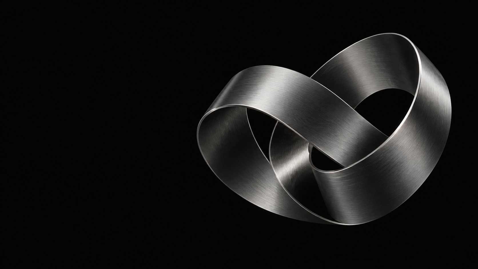 A continuous silver ribbon folded into a sculptural loop against a black background.